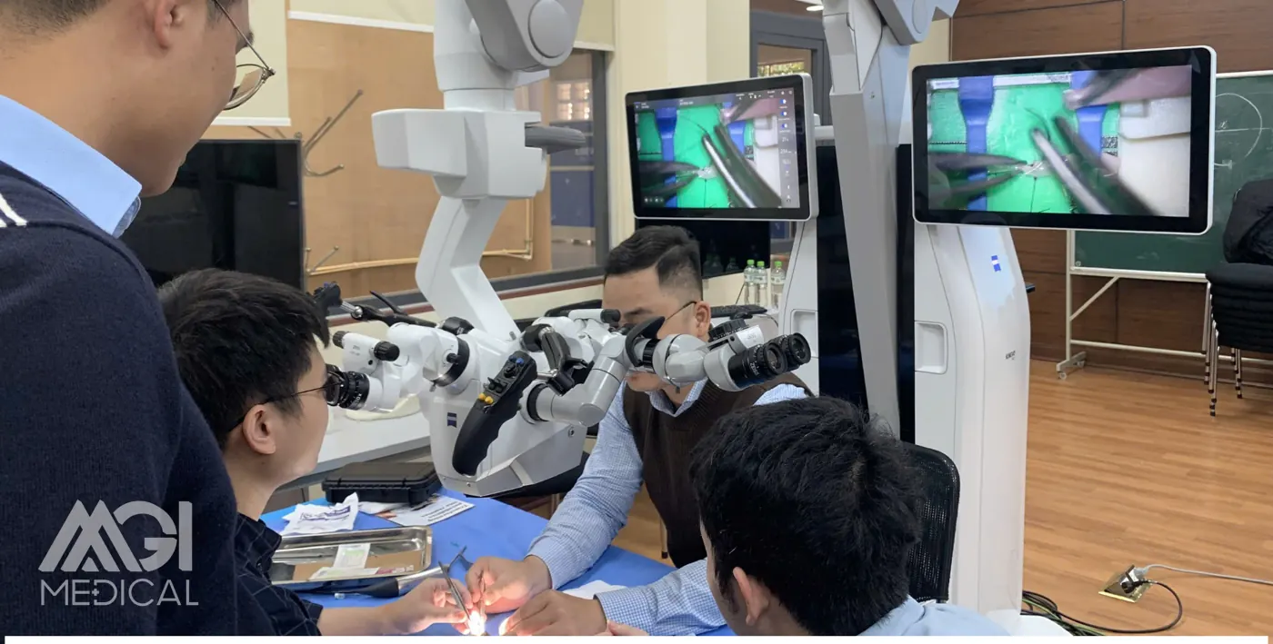 Practising under the operating microscope, with the field projected live onto the screen — basic microsurgery course in neurosurgery, Department of Surgery, Hanoi Medical University. Photo: MGI Medical.